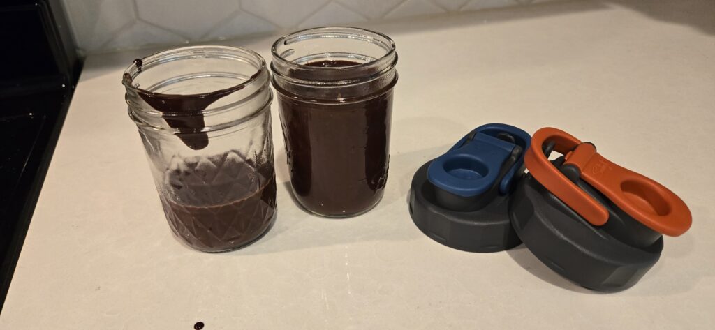 Homemade chocolate syrup cooling in the jars